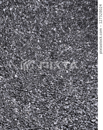 A vertical stock image of many small light charcoal gray crushed stones laid out 127328024