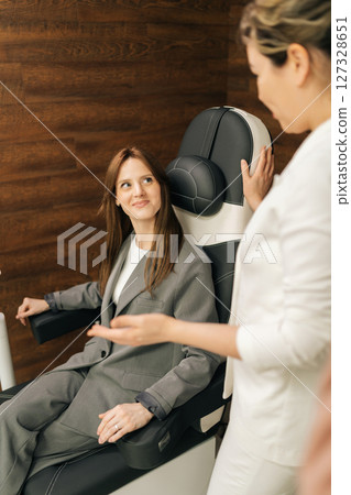 Vertical shot of medical specialist explaining pelvic floor muscle training, providing professional guidance, patient sitting on chair during consultation. Concept of innovative healthcare technology. Vertical shot of medical specialist explaining pelvic floor muscle training, providing professional guidance, patient sitting on chair during consultation. Concept of innovative healthcare technology. 127328651