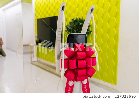Mesotherapy apparatus with festive bow in corridor of new beauty clinic or medical center, symbolizing innovation in skincare, aesthetic medicine, nobody. Concept of anti-age rejuvenation skincare. 127328680