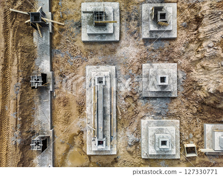 Monolithic reinforced concrete foundations or grillages for the construction of a large modern residential building. Rostverk at the construction site. Foundation for the building. View from above. 127330771