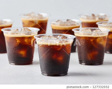 Iced coffee drinks in clear plastic cups are arranged on a light grey surface Iced coffee drinks in clear plastic cups are arranged on a light grey surface 127332032