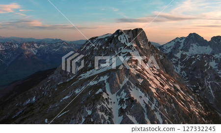 Rocky snow mountains at sunset aerial 127332245