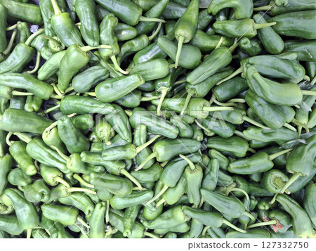 A large pile of padron green peppers ready for frying is showcased at a bustling market in Spain. The peppers boast a rich green color and are popular among local chefs. A large pile of padron green peppers ready for frying is showcased at a bustling market in Spain. The peppers boast a rich green color and are popular among local chefs. 127332750