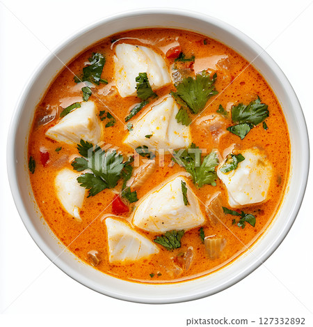 Creamy orange seafood stew with white fish chunks and herbs 127332892