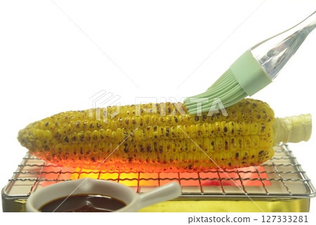 Grilling soy sauce flavored corn on a charcoal grill 127333281