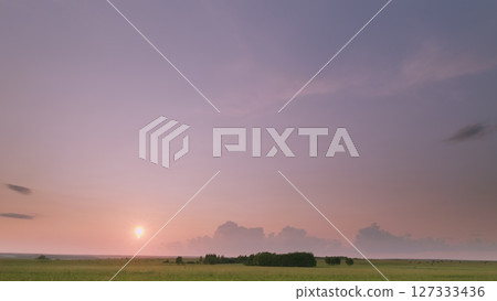 Time lapse. A Serene and Breathtaking Sunset Over Vast Open Fields Showcasing an Array of Beautiful Sky Colors Time lapse. A Serene and Breathtaking Sunset Over Vast Open Fields Showcasing an Array of Beautiful Sky Colors 127333436