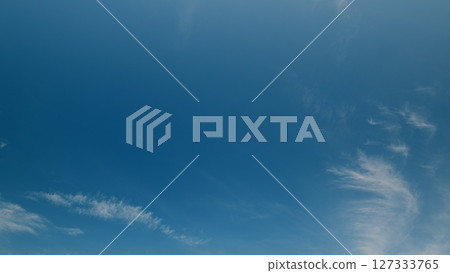 Time lapse. A magnificent clear blue sky adorned with delicate wispy clouds gracefully drifting by 127333765