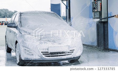 Man cleaning car. Spray hose foam soap. Car wash water shine exterior. Man cleaning car. Spray hose foam soap. Car wash water shine exterior. 127333785