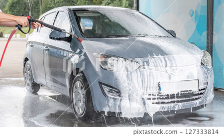Man cleaning car. Spray hose foam soap. Car wash water shine exterior. 127333814