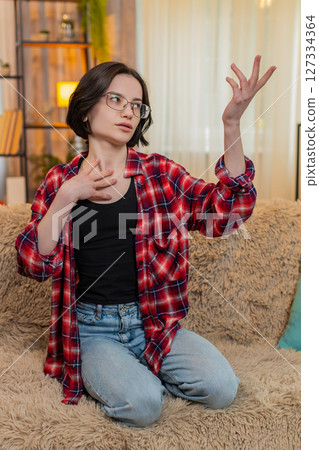 Young woman rehearsing monologue at home, gesturing with emotion and full theatrical engagement Young woman rehearsing monologue at home, gesturing with emotion and full theatrical engagement 127334364