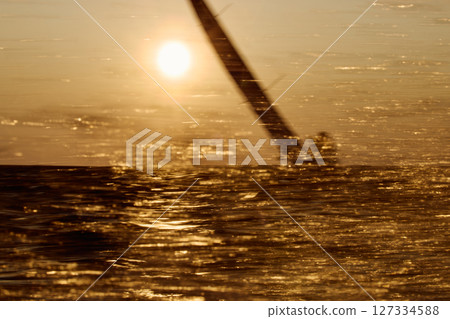 Sailing regatta in the Gulf of Finland at sunset, sailing yacht competing in a race, splashing water from under the boat, teamwork, board the boat 127334588