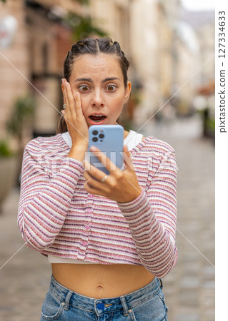Woman using smartphone shock sudden lottery results bad news fortune loss app fail virus thief fraud Woman using smartphone shock sudden lottery results bad news fortune loss app fail virus thief fraud 127334633
