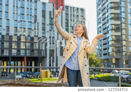 Mature female trying to catch a communication signal or Internet on mobile phone on downtown street 127334721