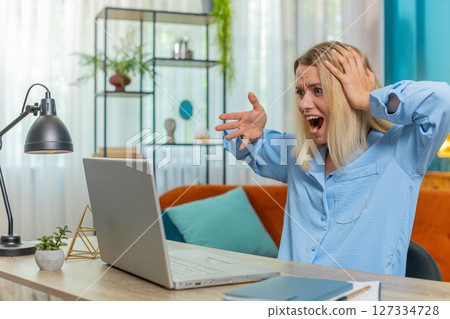 Displeased businesswoman using laptop surprised bad news fortune loss game fail computer virus error Displeased businesswoman using laptop surprised bad news fortune loss game fail computer virus error 127334728
