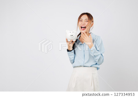 Happy woman holding piggy bank smiling excited with piggy save money win and showing success in finance, bank planning, and smart investment. isolated studio white background 127334953