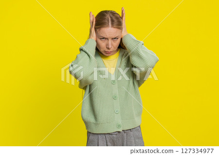 Annoyed irritated woman covering ears gesturing no avoiding advice ignoring noise loud voices 127334977