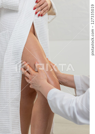 Experienced therapist doctor making woman relaxing spa anti-cellulite legs treatment hands massage 127335019