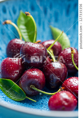 Fresh cherries fruits in a plate, macro photography, summer fruits. Abstract fruit food photo 127335356