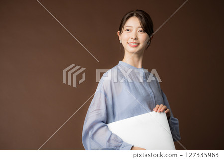 Business woman with laptop on brown background Business woman with laptop on brown background 127335963