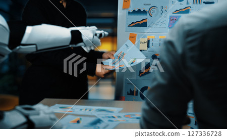 Futuristic Office Meeting with Robotic Arm Presenting Data Visualizations to Professional Team in Modern Workspace. Noogenesis Futuristic Office Meeting with Robotic Arm Presenting Data Visualizations to Professional Team in Modern Workspace. Noogenesis 127336728