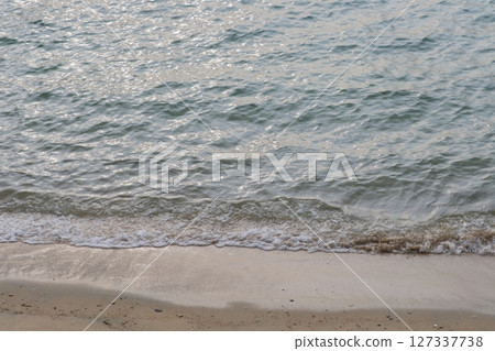 Small waves crashing on a quiet beach near dusk Small waves crashing on a quiet beach near dusk 127337738