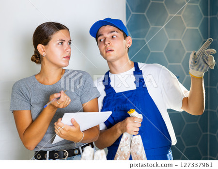 Contractor discussing apartment renovation work plan with woman customer 127337961