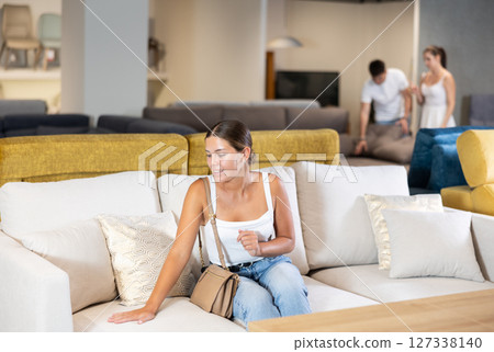 Young woman chooses sofa in store Young woman chooses sofa in store 127338140