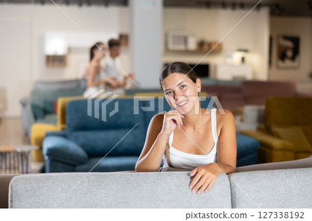 Young girl choosing convenient sofa in furniture shop Young girl choosing convenient sofa in furniture shop 127338192