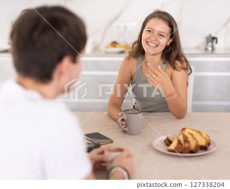 Young couple drinking tea and talking in kitchen Young couple drinking tea and talking in kitchen 127338204