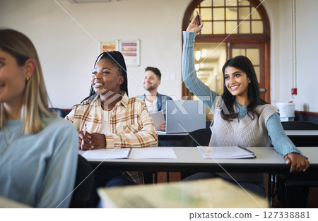 Question, education and learning with a student woman in a university or college class during a lesson. Classroom, study and scholarship with a female pupil raising her hand during an academy lecture 127338881