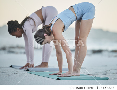 Diversity, women at the beach and doing yoga stretching for flexibility training, body healthcare exercise and mental focus. Leg stretch, outdoor pilates fitness workout and woman with friend by sea Diversity, women at the beach and doing yoga stretching for flexibility training, body healthcare exercise and mental focus. Leg stretch, outdoor pilates fitness workout and woman with friend by sea 127338882