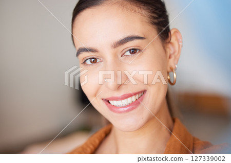 Portrait, face and beauty with a woman, happy indoors with her cosmetic skincare products or routine. Teeth, makeup and smile with an attractive young female posing inside with natural glowing skin 127339002