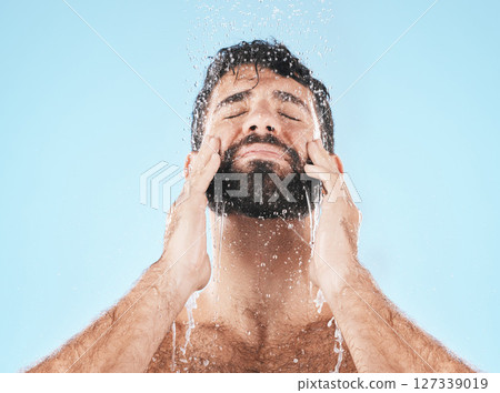 Man, shower and face cleaning for skincare hygiene, body care wellness and grooming health in blue background studio. Water splash, facial spa dermatology and cosmetics beauty or washing in morning Man, shower and face cleaning for skincare hygiene, body care wellness and grooming health in blue background studio. Water splash, facial spa dermatology and cosmetics beauty or washing in morning 127339019