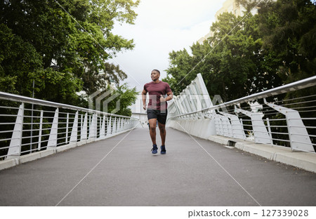 Running, bridge and black man athlete training for marathon run, wellness and sports. Speed cardio, runner workout and fitness workout of a man doing health exercise on a urban road in the morning Running, bridge and black man athlete training for marathon run, wellness and sports. Speed cardio, runner workout and fitness workout of a man doing health exercise on a urban road in the morning 127339028
