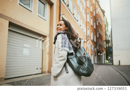 Back, woman and excited for travel, smile and relax for vacation, summer and town. Young female, student exchange or backpack for tourism, happiness or holiday for break, road trip or freedom in city 127339051