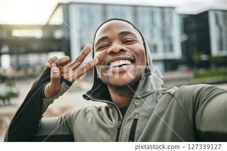 Fitness, selfie and man with peace sign in the city while doing a cardio exercise in Nigeria. Happy, smile and Nigerian guy taking picture while running for sports, race or marathon training in town. 127339127