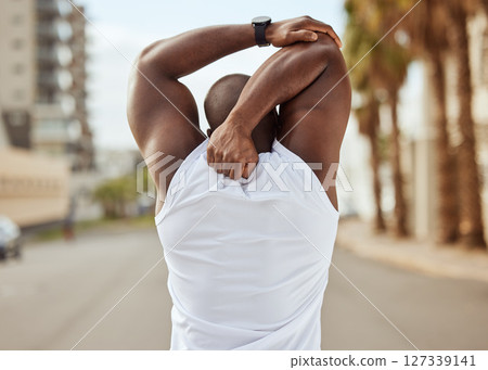 Back, black man and stretching in city, exercise and workout for wellness, health and cardio. African American male, healthy athlete and arms stretch for training, marathon and fitness for body care 127339141