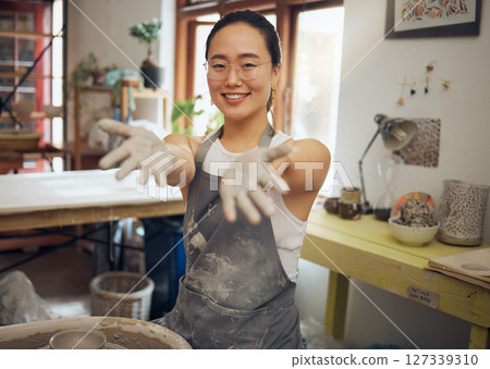 Portrait, clay pottery and Asian woman in studio, smile and sculpting for business, design art or creative. Hands, female entrepreneur or artist create ceramics, working on project or startup success 127339310