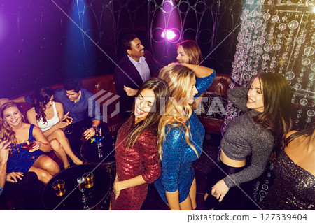 Night club, party and friends dance in disco for celebration, new years or VIP social event of music, drinks and entertainment. Group of people, dancing and crowd celebrate together in dark nightclub 127339404