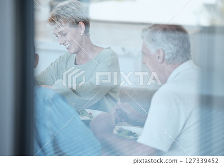 Love, celebration and family with dinner through window enjoy festive meal, lunch and eating food together. Christmas, thanksgiving and grandparents bonding, happy and laugh at dinner party at home 127339452