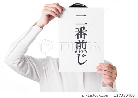 A person wearing a white shirt holding a piece of paper with the word "copycat" written on it 127339496