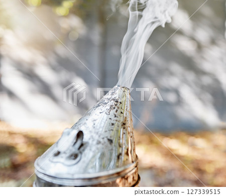 Beekeeping, smoker and honey production with farm equipment outdoor in the countryside during summer. Farming, nature and agriculture with a metal container for smoke in the beekeeper industry 127339515