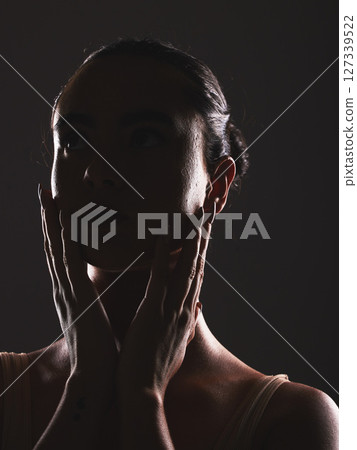 Woman, beauty and face silhouette in dark fantasy, cosmetics and dream aesthetics. Shadow, black background and model headshot while touching facial skin in mystery, studio background and erotic body 127339522