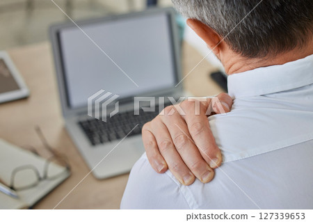 Shoulder pain, businessman at laptop in office with stress, anxiety and heart attack risk. Ceo, fatigue and cardiovascular problem of person working at corporate desk with burnout back view. 127339653