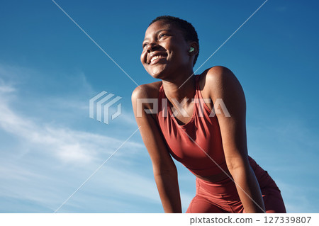 Fitness, black woman and happy athlete smile after running, exercise and marathon training workout. Blue sky, summer sports and run of a African runner breathing with happiness from sport outdoor 127339807