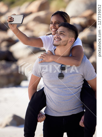 Beach, selfie and piggy back couple, smile with smartphone on romantic summer holiday at ocean. Romance, man and woman at with phone, love and vacation time for happy couple together in Australia. 127339852