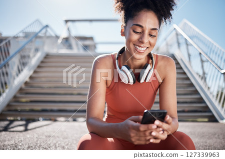 Fitness, phone and black woman in city on break on social media, texting or web browsing after exercise. Sports, cellphone and happy female athlete by stairs with 5g mobile smartphone for networking. 127339963