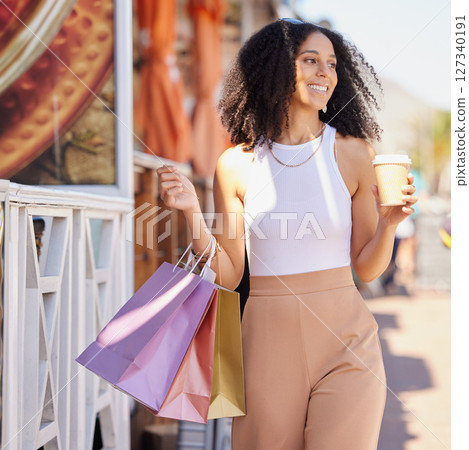 Black woman, shopping and coffee while happy, walking and thinking about sale, promotion and discount in city of France. Female customer on urban street with smile after retail trip during travel 127340191