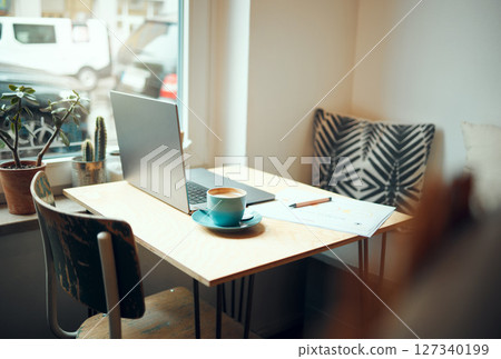 Laptop, documents and coffee shop with a table and chairs in an empty restaurant for freelance or remote work. Business, cafe and coffee with a pen and paper in a workspace at an internet cafe Laptop, documents and coffee shop with a table and chairs in an empty restaurant for freelance or remote work. Business, cafe and coffee with a pen and paper in a workspace at an internet cafe 127340199
