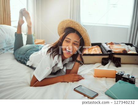Happy, travel packing and woman on a hotel bed with suitcase ready for summer vacation. Luggage, bedroom and smile of a person relax in accommodation with clothes or happiness about traveling journey 127340232